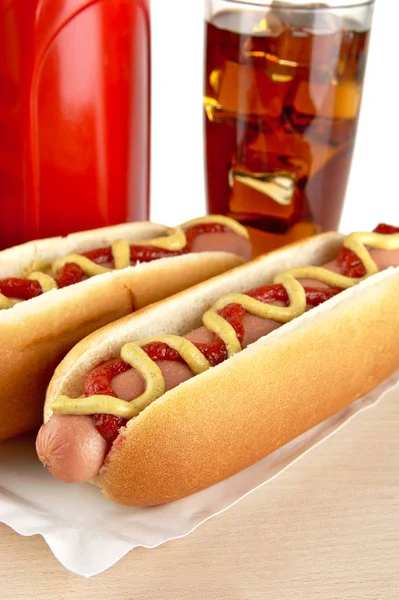 Hotdogs zum Abendessen mit Coca-Cola auf Holz lizenzfreie Stockfotos