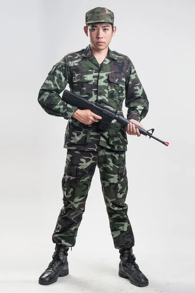 Soldado asiático en uniforme de camuflaje verde con pistola larga — Foto de Stock