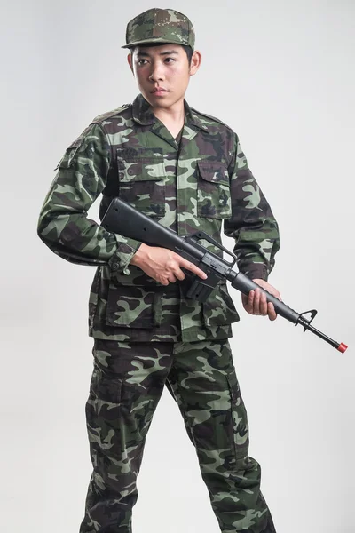 Soldado asiático em uniforme camuflagem verde com arma longa — Fotografia de Stock