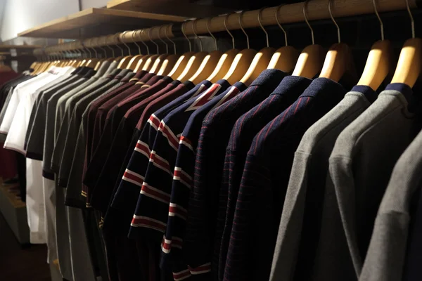 Camisetas masculinas no rack no quarto escuro Foco suave — Fotografia de Stock