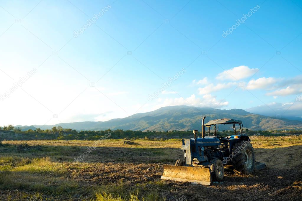 soil tractor in the farmland with beautiful mountain behind