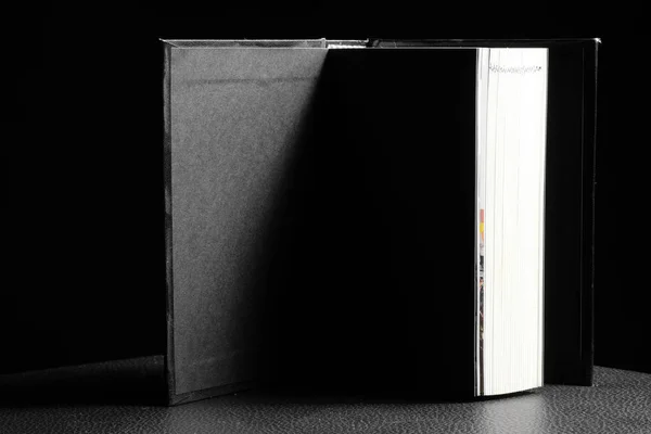 Libro con copertina rigida su sfondo nero — Foto Stock