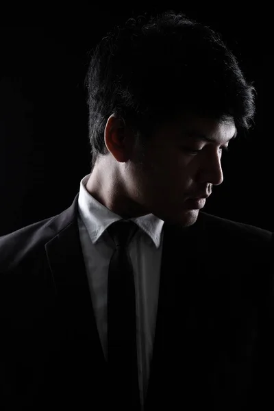 Asian man in black formal suit in the dark — Stock Photo, Image