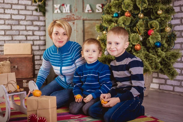 Mamá y dos hijos cerca del árbol de Navidad —  Fotos de Stock