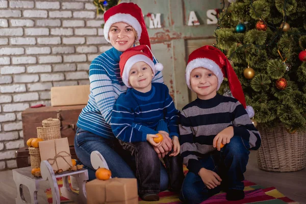 Mãe e dois filhos perto da árvore de Natal — Fotografia de Stock