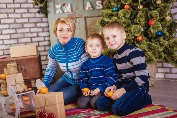 Mãe e dois filhos perto da árvore de Natal — Fotografia de Stock