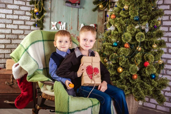 Dos sombreros de los muchachos de Santa Claus cerca del árbol de Navidad —  Fotos de Stock