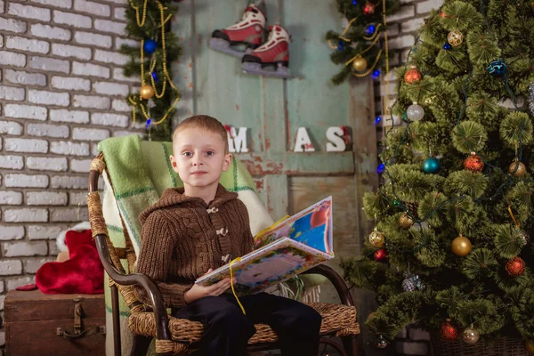 Gutten leser nær juletreet – stockfoto