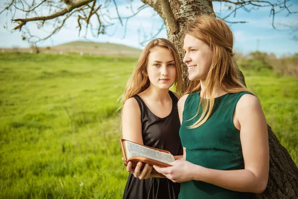 Due ragazze che leggono un libro all'aperto — Foto Stock