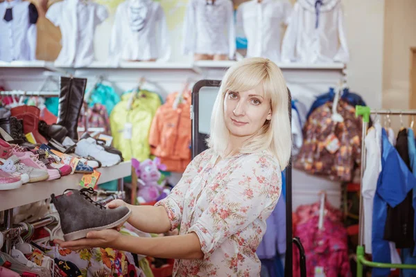 Frau im Supermarkt kauft Schuhe — Stockfoto