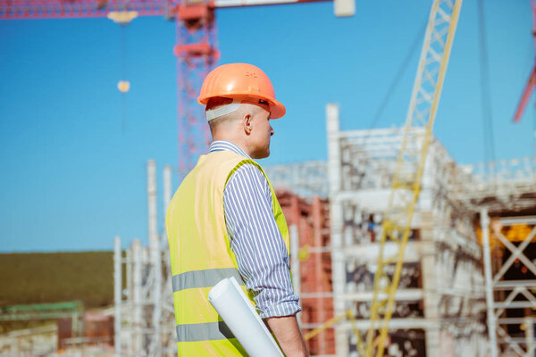 Portrait of a male engineer on a construction site background
