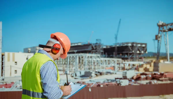 Porträtt av en manlig ingenjör på en konstruktion webbplats bakgrund — Stockfoto