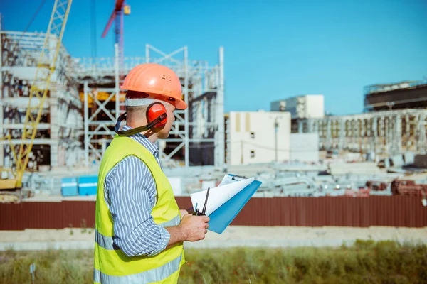 İnşaat site arka plan üzerinde erkek bir mühendis portresi