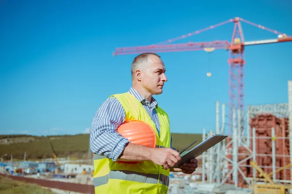 Porträtt av en manlig ingenjör på en konstruktion webbplats bakgrund — Stockfoto