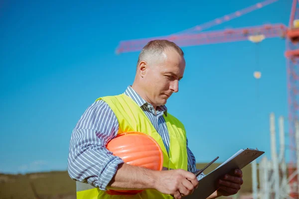 Porträtt av en manlig ingenjör på en konstruktion webbplats bakgrund — Stockfoto