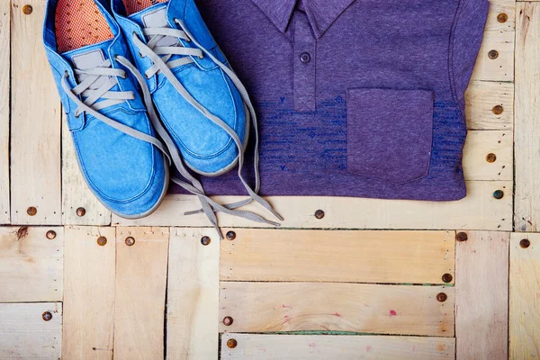 Zapatillas y una camisa sobre un fondo de madera — Foto de Stock