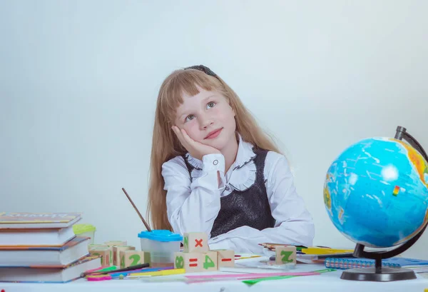 Schoolgirl with books sitting at table — Stock Photo, Image