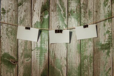 Boş kağıda bir ip üzerinde bir ahşap arka plan asılı. Ahşap arka plan üzerine Not kağıtları