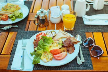  Kahvaltıda. Bir tabak omlet, pastırma ve taze sebze.