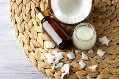 Hindistan cevizi yağı, hindistan cevizi organik kozmetik ürünleri ve ahşap masadaki doğu paspası üzerinde taze hindistan cevizi.