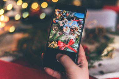 Kadın masanın üstünde noel pastalarının fotoğrafını çekiyor..