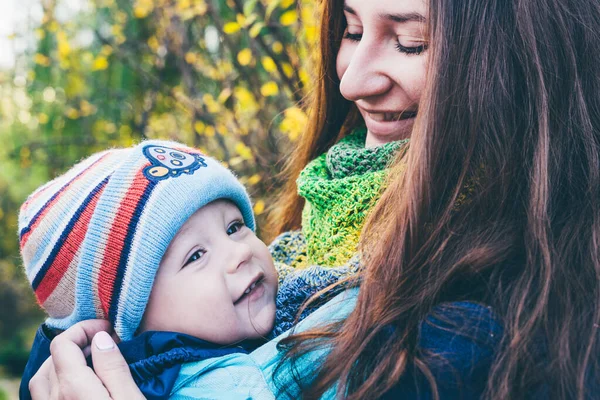 Mother with her son in a sling scarf in a botanical garden. — Stock Photo, Image