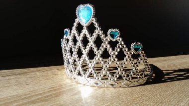 Mavi taşlı bir taç yan aydınlatmada parlıyor.