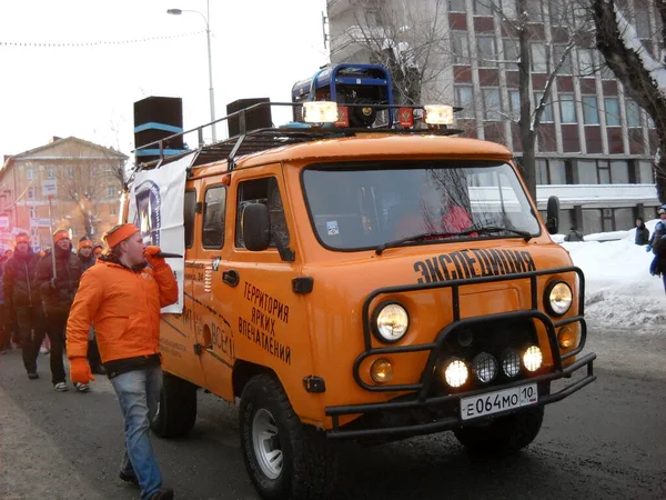 Petrozavodsk, Karelia Cumhuriyeti, Rusya - 9 Kasım 2019: Soğuk bir kış gününde insanlar bir sokak festivalinde. Motorlu taşıtlarla ilgili bir gösteri. Rus arabası turuncu.. — Stok fotoğraf