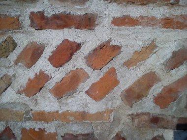 Eski Roma tuğlası. Roma döneminin yenilenmiş duvarı. Güneş ışığı, çapraz çizgiler ve düz olmayan tuğlaların sıcak kahverengi tonları. Sırbistan ve Sremska Mitrovica 'daki arkeoloji sahası