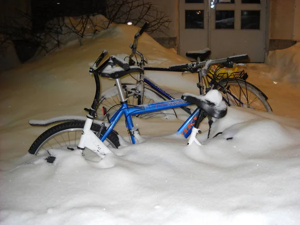 Helsinki, Finlandia - 31 de diciembre de 2018 una bicicleta estacionada en el patio de un edificio de apartamentos lleno de nieve blanca fresca. La tarde nevada de Año Nuevo en Finlandia . — Foto de Stock