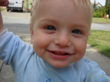 Sremska Mitrovica / Sırbistan - 01 Eylül 2013: Kafkas çocuk sevindi. Oğlanın sarı saçları var ve mavi bir bluz giyiyor. İlk yaprak döken dişler açık ağızdan görülebilir.