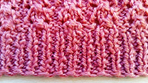 ホーム編み物針。赤い色の毛糸。製品の底は弾性バンド技術と結びついています。エッジループはきれいに結合され、平らなエッジを作成します. — ストック写真