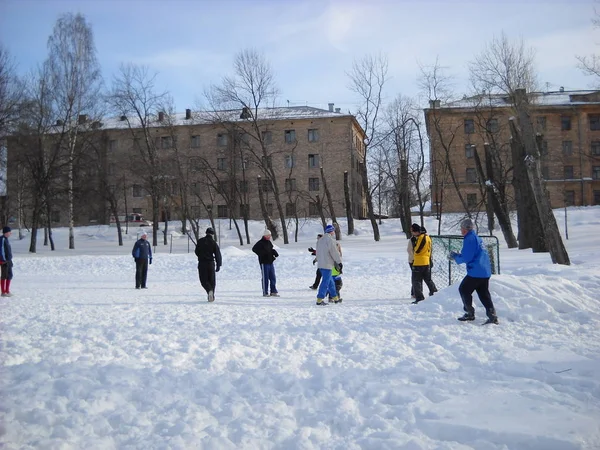 Москва, Россия - 8 марта 2019 года мужчины играют в футбол на снегу. Зимний спорт. Мужчины забивают гол. Спортсмены нападают на кого-то еще, чтобы забить гол. Теплая одежда не мешает быстрому движению — стоковое фото