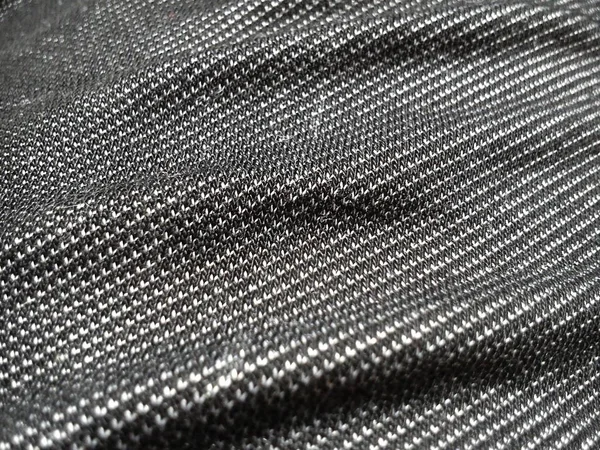 Текстильна тканина, зроблена на ткацькому верстаті шляхом плетіння взаємно перпендикулярних систем ниток. Чорно-біла синтетична поліефірна тканина для шиття одягу, оббивки та інших виробів. Матеріал крупним планом — стокове фото
