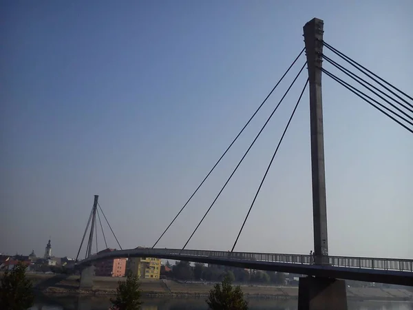 Híd a Száva folyó felett Sremska Mitrovica városában, Szerbiában. Új betonhíd fém kábelekkel. Mérnöki építőipari technológiák. Az ellenkező parton van egy régi európai város. — Stock Fotó