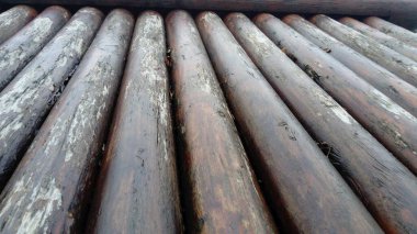 Uzunlamasına testere kullanmadan inşaatta kullanılacak bir kütük. Yuvarlak kereste çeşidi. Yuvarlak ahşap kütüklerin yapımının bir parçası. Nemin ahşap üzerindeki etkisi