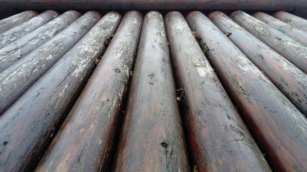 El efecto de la humedad en la madera. Un tronco de construcción para su uso en construcción sin aserrado longitudinal. Surtido de madera redonda. Fragmento de la construcción de troncos redondeados de madera . — Foto de Stock