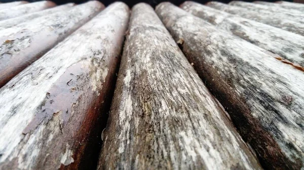 O efeito da umidade na madeira. Um tronco de construção para uso em construção sem serragem longitudinal. Variedade de madeira redonda. Fragmento da construção de troncos de madeira arredondados . — Fotografia de Stock