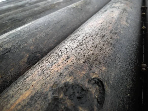 El efecto de la humedad en la madera. Un tronco de construcción para su uso en construcción sin aserrado longitudinal. Surtido de madera redonda. Fragmento de la construcción de troncos redondeados de madera . —  Fotos de Stock