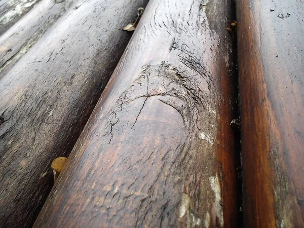 El efecto de la humedad en la madera. Un tronco de construcción para su uso en construcción sin aserrado longitudinal. Surtido de madera redonda. Fragmento de la construcción de troncos redondeados de madera . —  Fotos de Stock