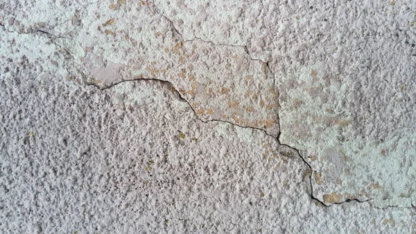 Crack on the wall of the house. Old plaster falls off the surface. Defect during construction. The effect of humidity on the structure. Violation of the technology of the construction process — ストック写真