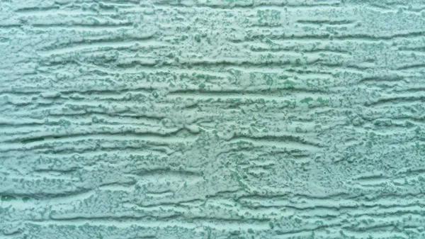 Parede verde rebocada. A camada de acabamento é formada por argamassa endurecida. A textura do cimento é aplicada com uma espátula. O uso de gesso decorativo no interior está se tornando um tipo comum de decoração — Fotografia de Stock