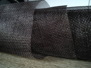 Sivrisinek ağı. Beyaz arka planda kahverengi sentetik malzeme. Plastik iplikler örüyorum. Karmaşık kafes.