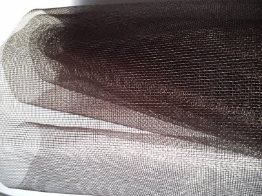 Sivrisinek ağı. Beyaz arka planda kahverengi sentetik malzeme. Plastik iplikler örüyorum. Karmaşık kafes.