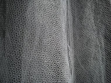 Beyaz buruşuk ağ kumaşı. Sentetik malzemeden yapılmış yıkanabilir bir şey. Sivrisinek ağı yumuşak kıvrımlara katlandı. Duvağa benzeyen kumaş.