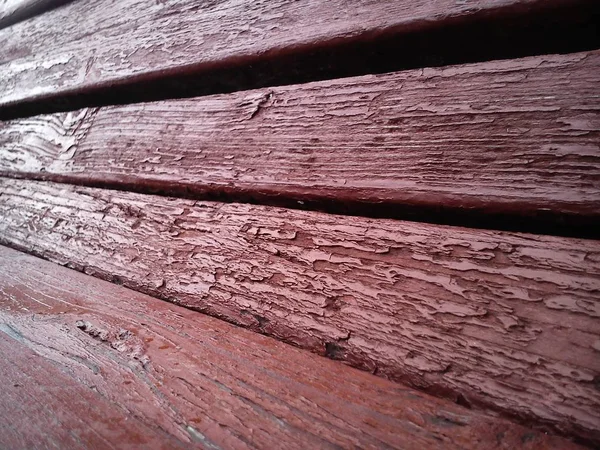 Textura de madeira. Banco de madeira pintado em Borgonha com tinta a óleo. Rachaduras no tronco. O produto das placas. Humidade em madeira — Fotografia de Stock