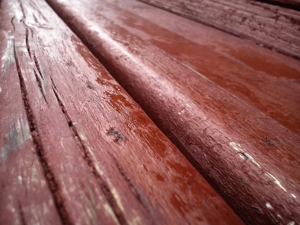 Textura de madeira. Banco de madeira pintado em Borgonha com tinta a óleo. Rachaduras no tronco. O produto das placas. Humidade em madeira — Fotografia de Stock