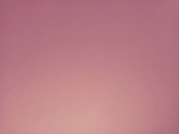 Soft pink background. A sheet of paper with different lighting. Blush shade. Can be used as a background or as a sample of cosmetics for face, blush or lipstick.
