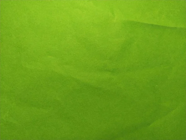 Лист товстого зеленого паперу, злегка зморщеного. Нерівномірне освітлення — стокове фото
