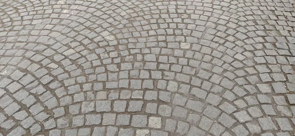 Cobblestone plein in de oude wijk van de stad. Vierkante en oneffen stenen zijn betegeld. Achtergrond. Zacht grijs, beige en bruine kleuren en tinten. Achtergrond, vrije ruimte voor tekst. Kopieerruimte — Stockfoto